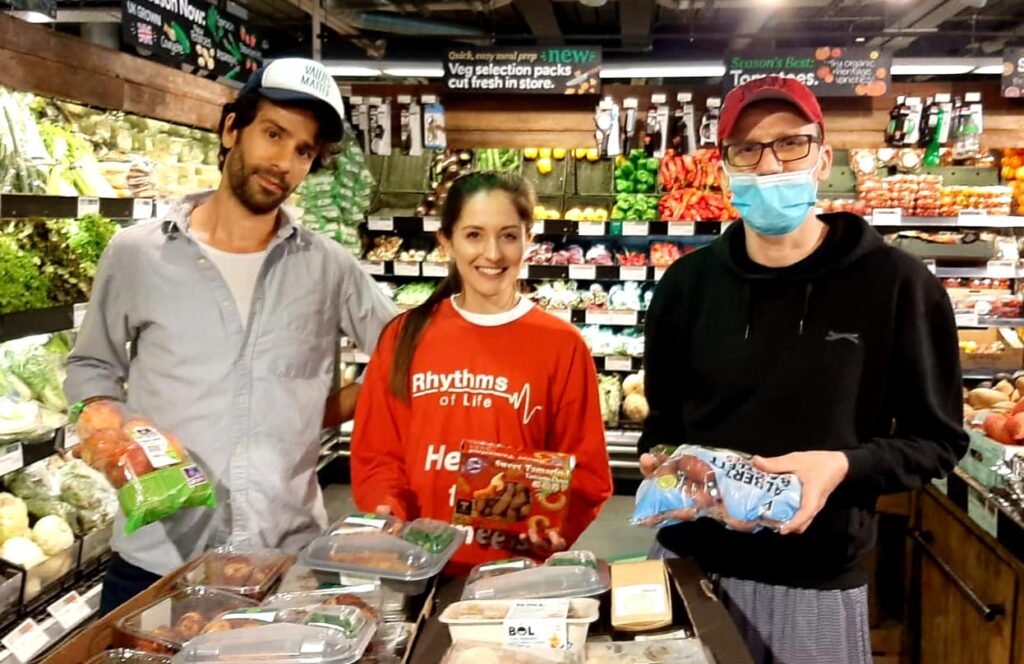 Image of a volunteer in the fruit and veg section at Mr Organic with 2 of their staff